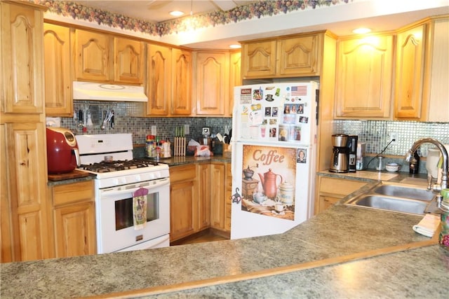 kitchen with decorative backsplash, white appliances, and sink