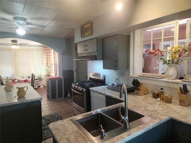 kitchen with gas range, dishwasher, backsplash, gray cabinets, and light tile patterned flooring