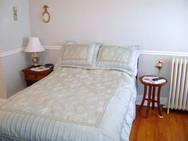 bedroom featuring hardwood / wood-style flooring and radiator