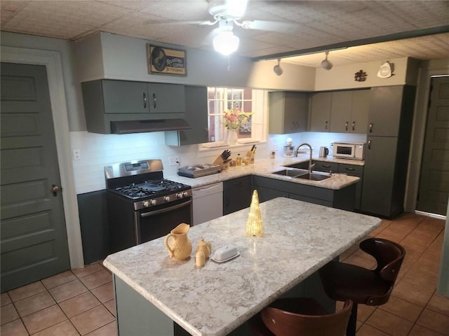 kitchen with sink, rail lighting, white appliances, gray cabinets, and a kitchen island