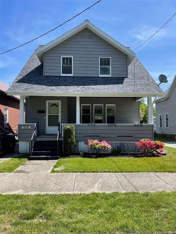 bungalow-style house with covered porch and a front yard