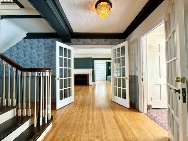 hallway featuring hardwood / wood-style flooring, crown molding, and french doors