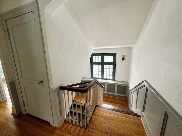 stairs with crown molding, french doors, and hardwood / wood-style flooring