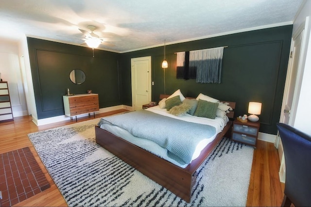 bedroom featuring hardwood / wood-style flooring, ceiling fan, and crown molding