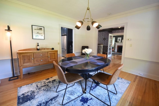 dining room featuring a chandelier, light hardwood / wood-style floors, and ornamental molding