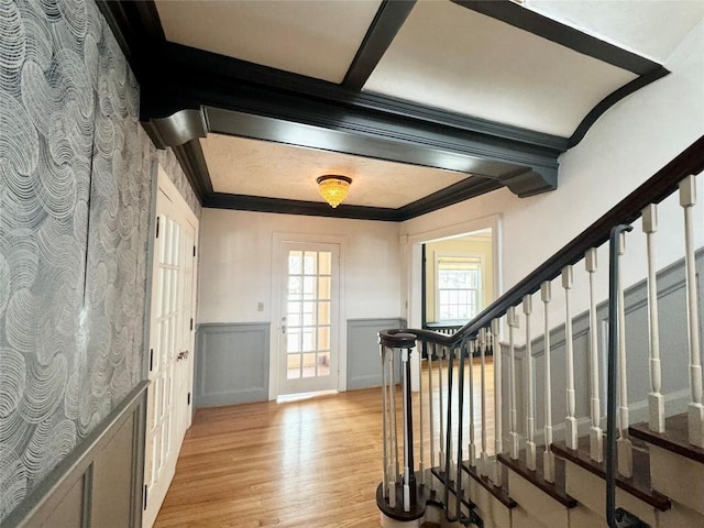 foyer entrance with light hardwood / wood-style floors and ornamental molding