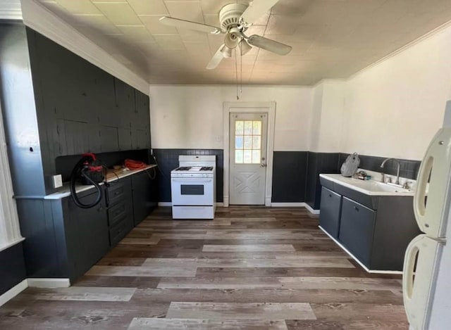 1121 E 27th St, Erie, PA 16504 - kitchen featuring white appliances, a ceiling fan, wood finished floors, a wainscoted wall, and a sink