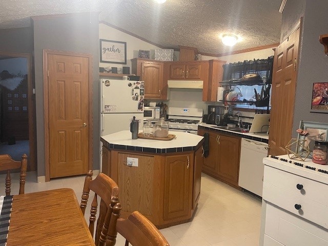 kitchen with sink, a kitchen island, white appliances, and a textured ceiling