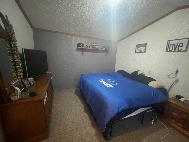 bedroom with a textured ceiling, ornamental molding, carpet, and lofted ceiling