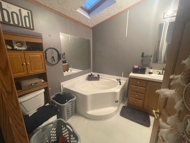 bathroom with a textured ceiling, ornamental molding, a washtub, a skylight, and vanity