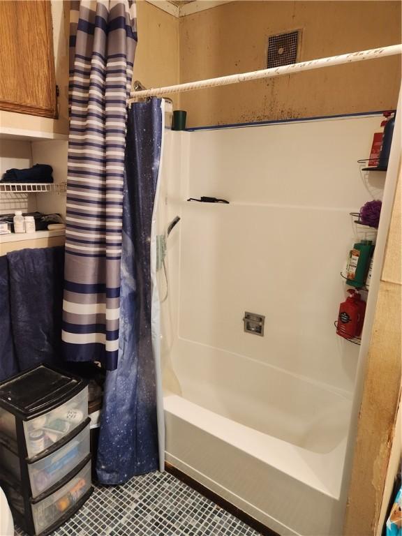 bathroom featuring backsplash and shower / tub combo with curtain