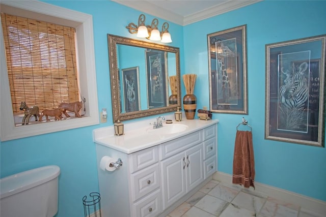 bathroom with toilet, vanity, and ornamental molding