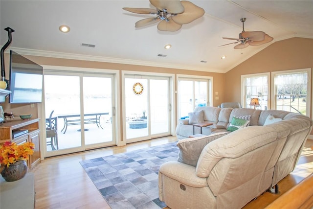 living room featuring a wealth of natural light, crown molding, and lofted ceiling