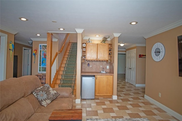 kitchen featuring refrigerator, tasteful backsplash, crown molding, and sink