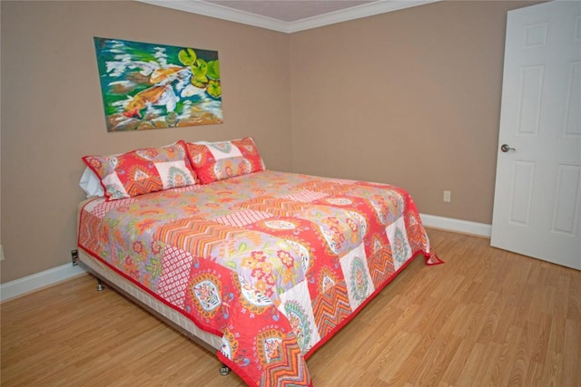 bedroom with hardwood / wood-style flooring and ornamental molding