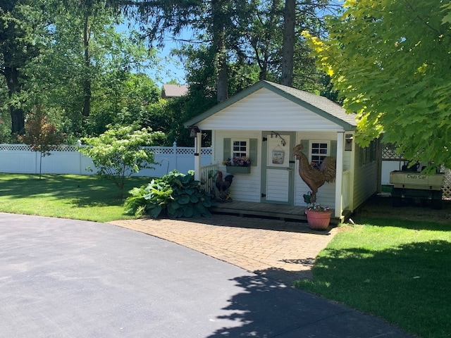 view of front of property featuring an outdoor structure and a front yard