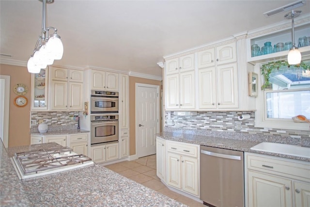 kitchen featuring appliances with stainless steel finishes, backsplash, crown molding, light tile patterned floors, and hanging light fixtures