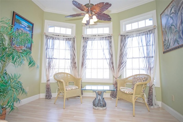 sitting room with ceiling fan, ornamental molding, and light hardwood / wood-style flooring