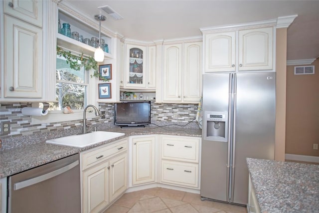 kitchen featuring dark stone countertops, light tile patterned floors, sink, and appliances with stainless steel finishes