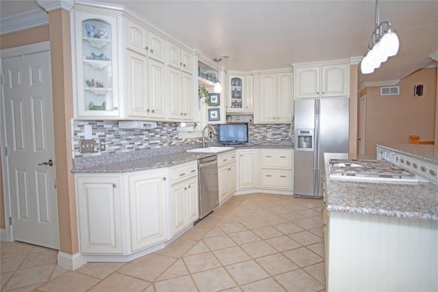 kitchen with light stone countertops, stainless steel appliances, decorative light fixtures, decorative backsplash, and light tile patterned floors