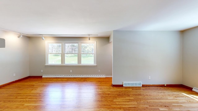 9170 Storey Rd, North East, PA 16428 - empty room featuring light wood finished floors, rail lighting, baseboards, and baseboard heating