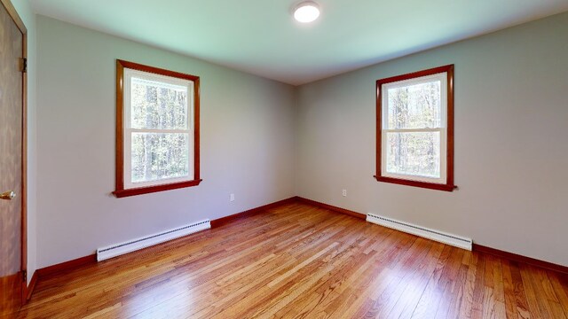 9170 Storey Rd, North East, PA 16428 - empty room featuring baseboard heating, a baseboard radiator, light wood-style flooring, and baseboards