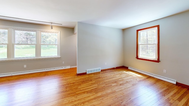 9170 Storey Rd, North East, PA 16428 - spare room featuring a baseboard heating unit, light wood finished floors, and healthy amount of natural light