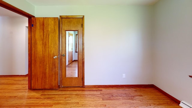 9170 Storey Rd, North East, PA 16428 - unfurnished room featuring a baseboard heating unit, light wood-style floors, and baseboards