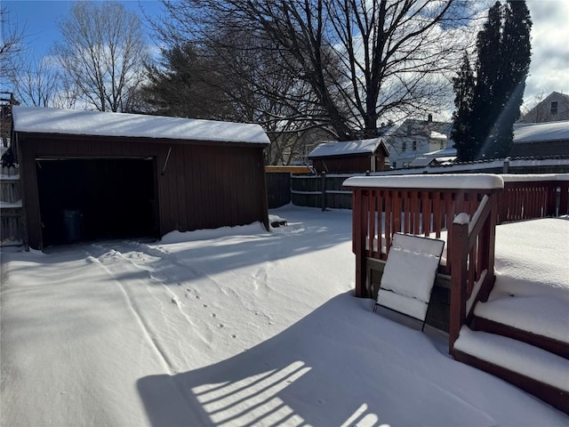 yard covered in snow with a garage and an outdoor structure