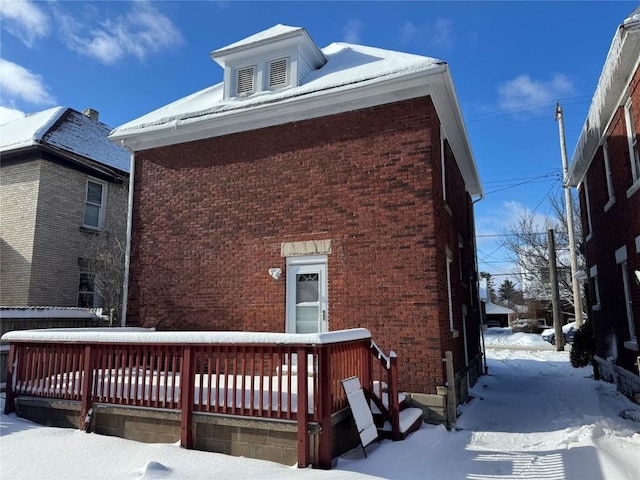 view of snowy exterior with a deck