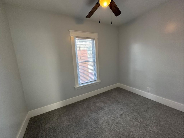 empty room with ceiling fan and dark colored carpet