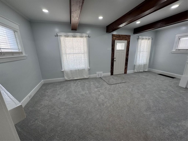 carpeted foyer entrance with beamed ceiling