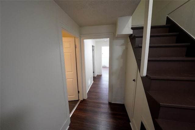 hallway featuring a textured ceiling, a baseboard radiator, and dark hardwood / wood-style floors