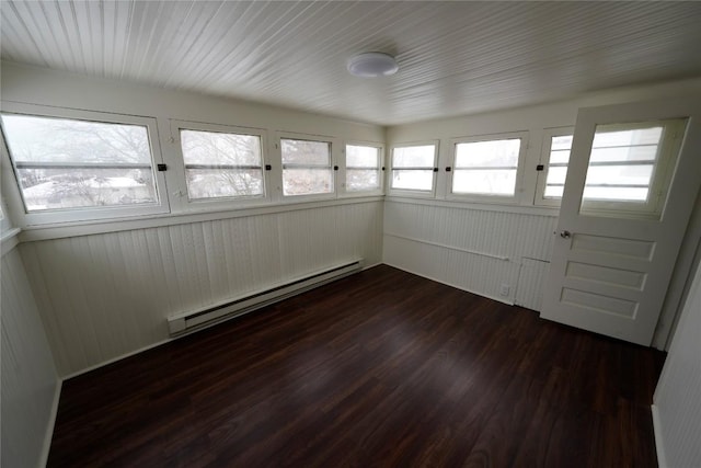 spare room featuring baseboard heating and dark hardwood / wood-style floors