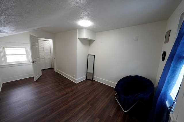 hallway featuring a textured ceiling and dark wood-type flooring