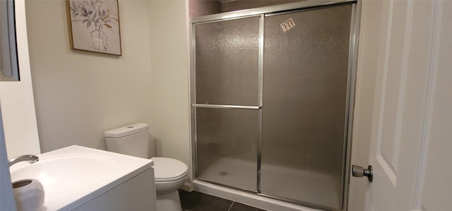 bathroom featuring tile patterned flooring, vanity, toilet, and an enclosed shower