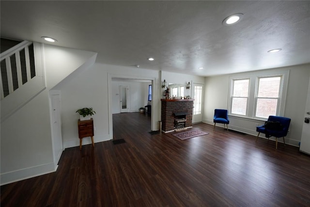 interior space featuring dark hardwood / wood-style flooring and a brick fireplace