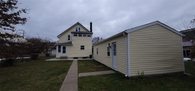 rear view of property featuring a lawn