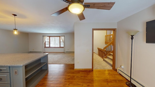 kitchen with hardwood / wood-style floors, baseboard heating, gray cabinetry, and ceiling fan