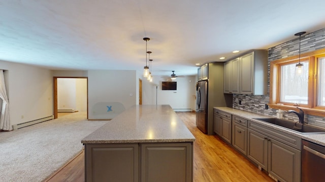 kitchen with decorative light fixtures, a center island, sink, and stainless steel appliances