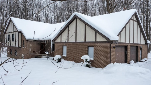 view of snowy exterior with a garage