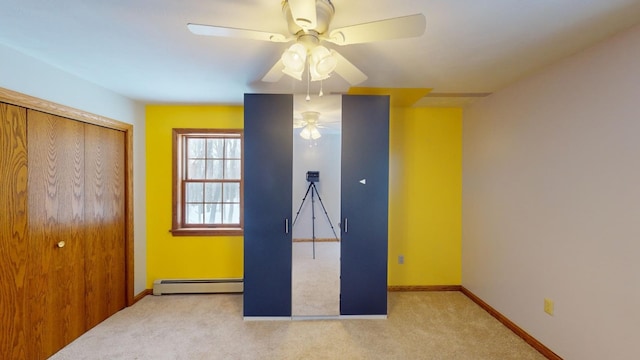 unfurnished bedroom featuring light carpet, a closet, ceiling fan, and a baseboard heating unit