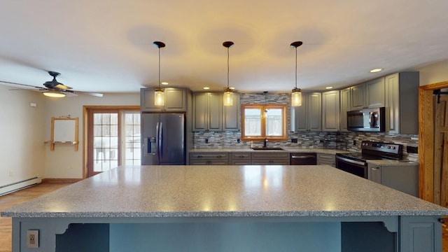 kitchen with a center island, sink, ceiling fan, decorative backsplash, and appliances with stainless steel finishes