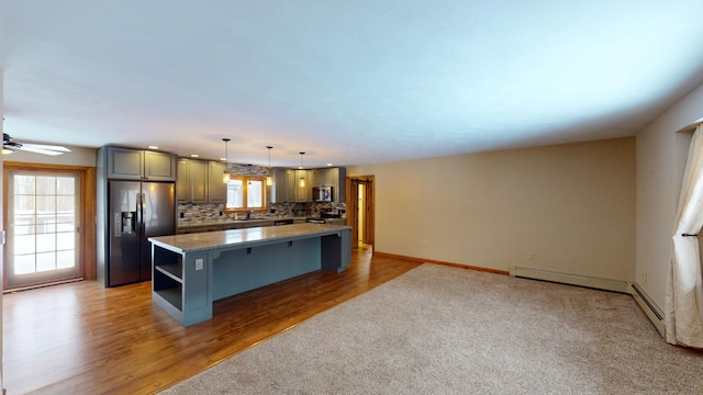 kitchen featuring a center island, sink, hanging light fixtures, decorative backsplash, and stainless steel appliances