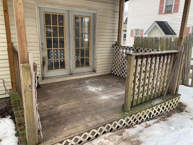 snow covered deck featuring french doors