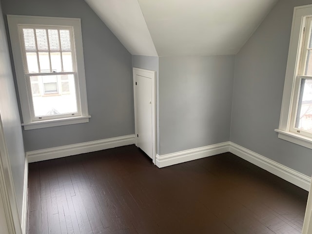 bonus room with dark hardwood / wood-style floors and vaulted ceiling