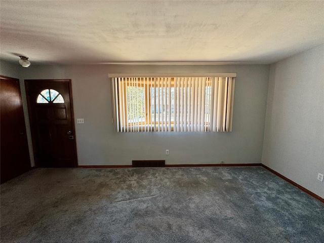 foyer with a wealth of natural light, visible vents, a textured ceiling, and baseboards