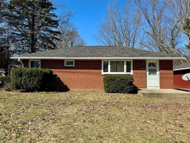 view of front facade with brick siding and a front lawn