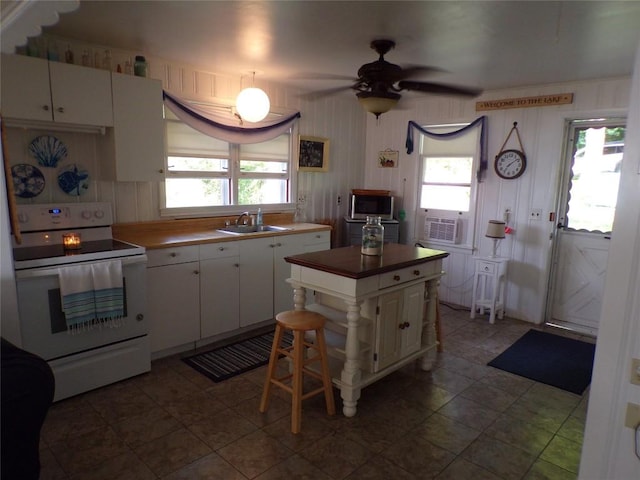 179 Elk Creek Rd, Lake City Boro, PA 16423 - kitchen featuring electric stove, white cabinetry, ceiling fan, cooling unit, and a center island