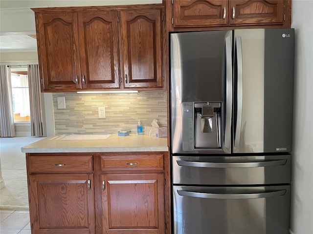 kitchen with backsplash, stainless steel fridge, and ornamental molding